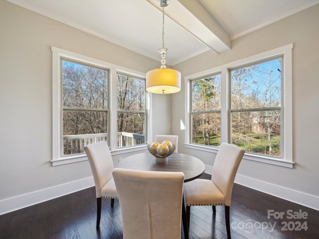 dining space featuring dark hardwood / wood-style flooring, beamed ceiling, and a healthy amount of sunlight