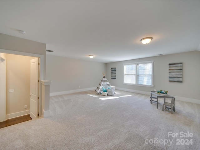 recreation room with light colored carpet