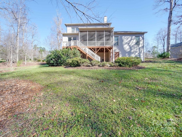 rear view of property featuring a sunroom and a lawn