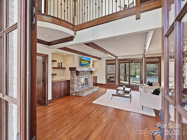 living room featuring hardwood / wood-style flooring, beam ceiling, and a fireplace