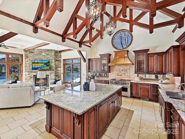 kitchen with a kitchen island, double oven range, sink, and high vaulted ceiling