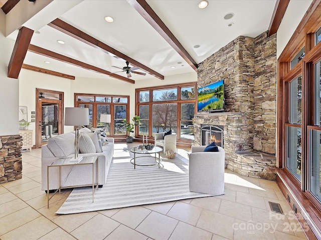 tiled living room with a fireplace, beam ceiling, and ceiling fan