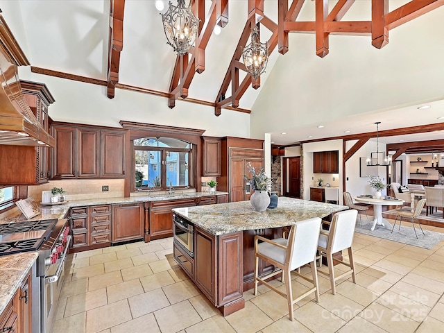 kitchen with beamed ceiling, a kitchen island, hanging light fixtures, and high vaulted ceiling