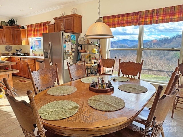 tiled dining room with crown molding and sink