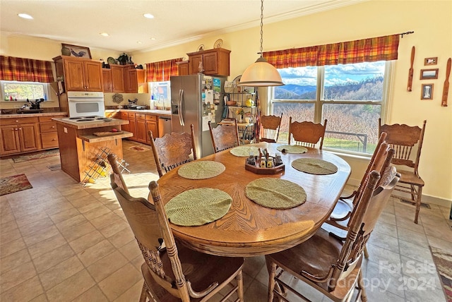 tiled dining space featuring ornamental molding and sink