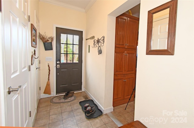 entryway with light tile patterned flooring and crown molding