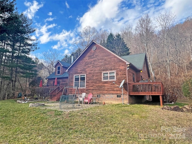 back of property with a lawn and a wooden deck