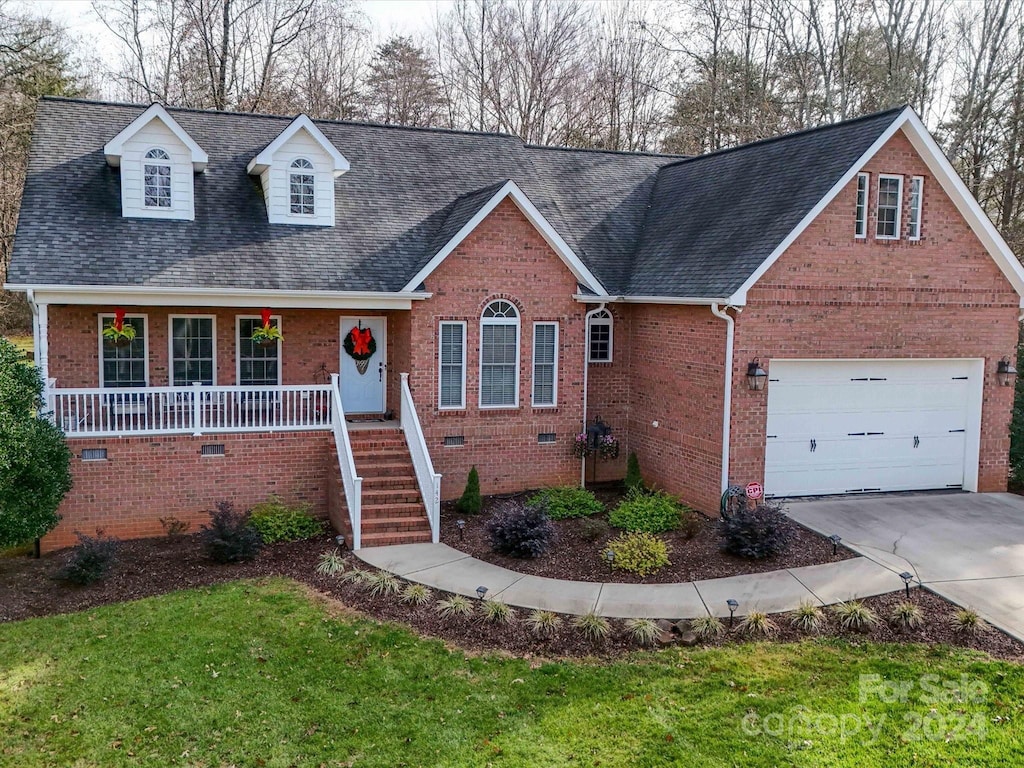 cape cod house with a front lawn, a porch, and a garage