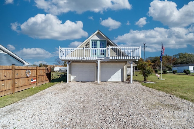 view of front facade with a front yard, a garage, and a wooden deck