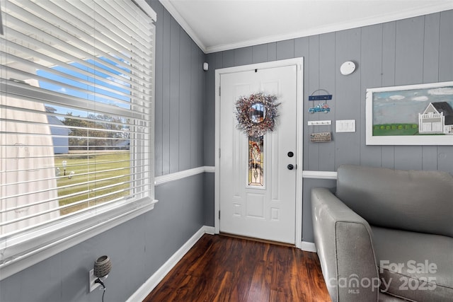 foyer entrance with crown molding, wood walls, and dark hardwood / wood-style floors