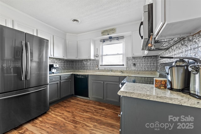 kitchen featuring gray cabinetry, dishwasher, sink, dark hardwood / wood-style floors, and stainless steel fridge