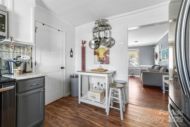 kitchen featuring appliances with stainless steel finishes, a textured ceiling, ornamental molding, and gray cabinetry