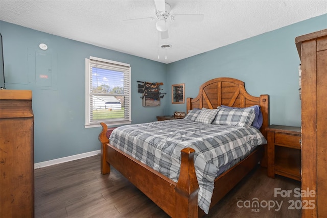 bedroom with a textured ceiling, dark hardwood / wood-style floors, and ceiling fan