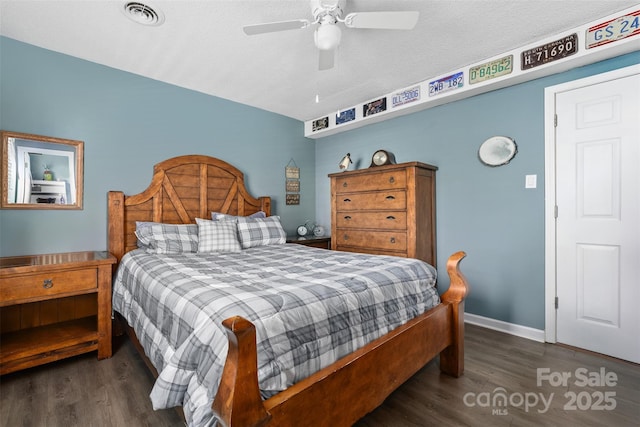 bedroom featuring ceiling fan, dark wood-type flooring, and a textured ceiling