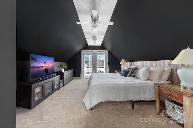 bedroom with a textured ceiling, ceiling fan, light carpet, and vaulted ceiling