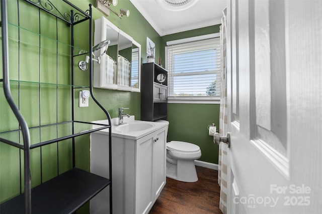 bathroom with vanity, toilet, ornamental molding, and wood-type flooring