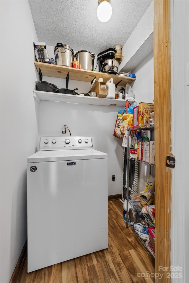 laundry area featuring dark hardwood / wood-style floors, washer / dryer, and a textured ceiling