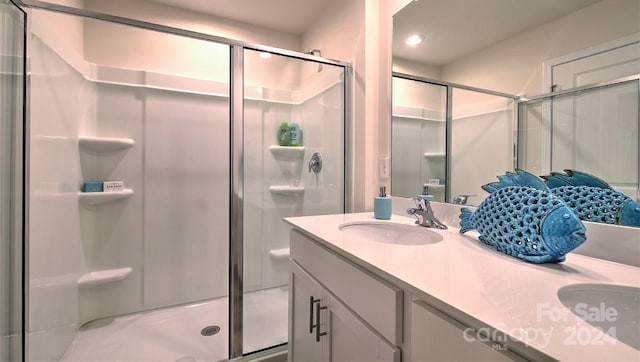 bathroom with vanity and a shower with door