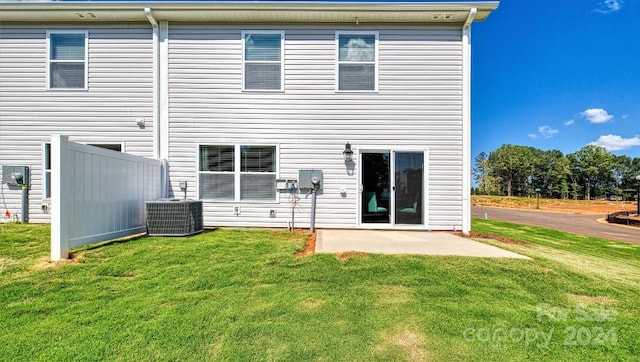 rear view of property with central air condition unit, a patio area, and a yard