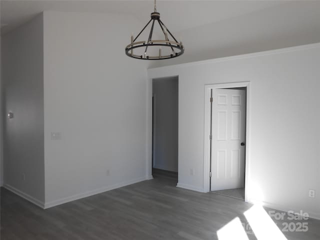 interior space with baseboards, a chandelier, and wood finished floors