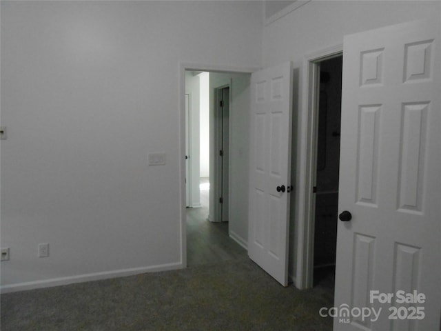 hallway featuring carpet floors and baseboards