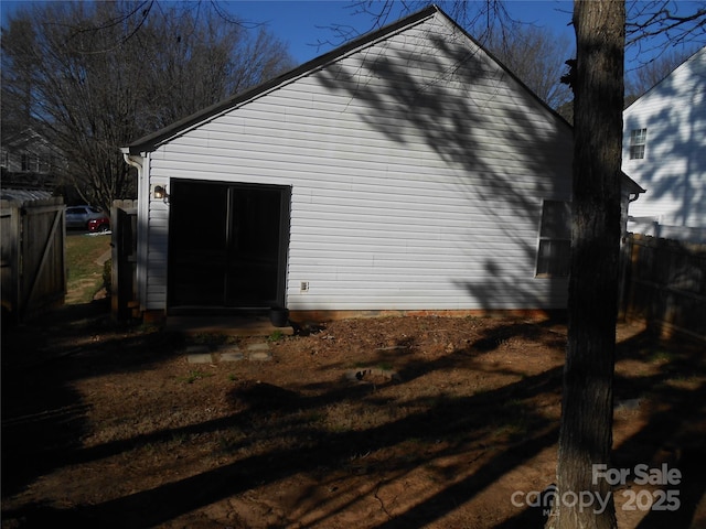 view of side of home featuring fence