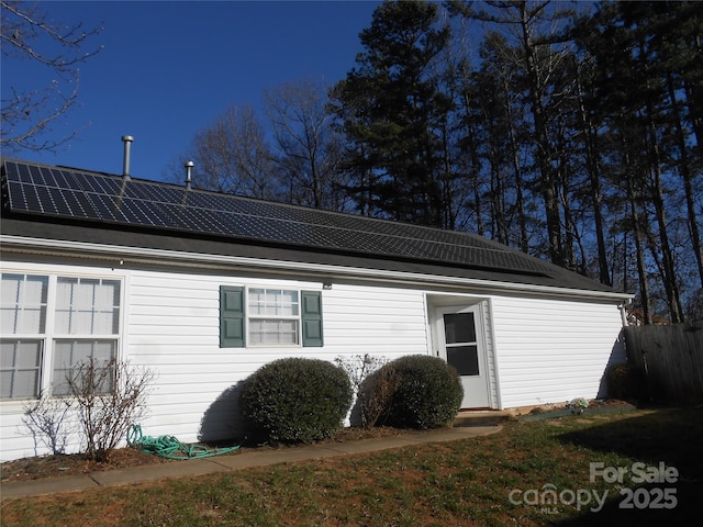 view of side of home featuring solar panels