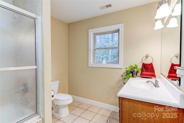 bathroom with tile patterned flooring, vanity, a shower with shower door, and toilet