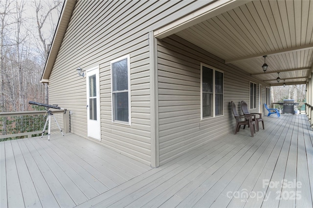 wooden deck featuring area for grilling and ceiling fan