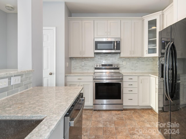 kitchen featuring appliances with stainless steel finishes, tasteful backsplash, and white cabinetry