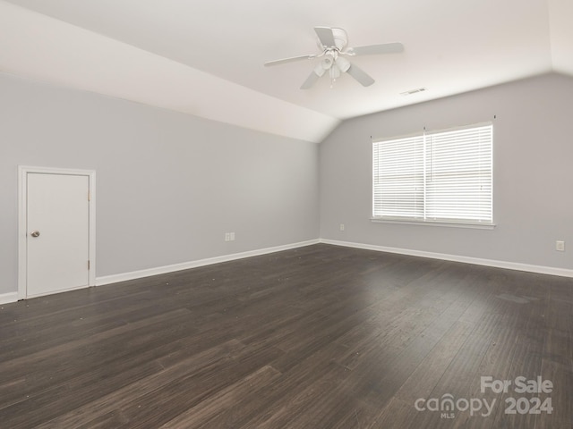 spare room with ceiling fan, dark hardwood / wood-style floors, and vaulted ceiling