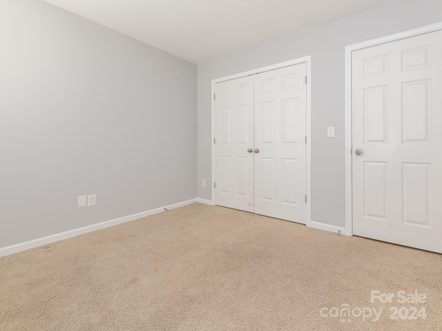 unfurnished bedroom with carpet floors and a closet