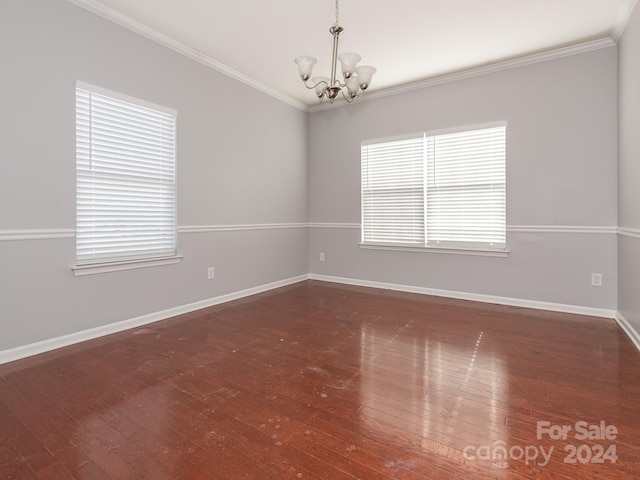 empty room with a chandelier, ornamental molding, and a healthy amount of sunlight