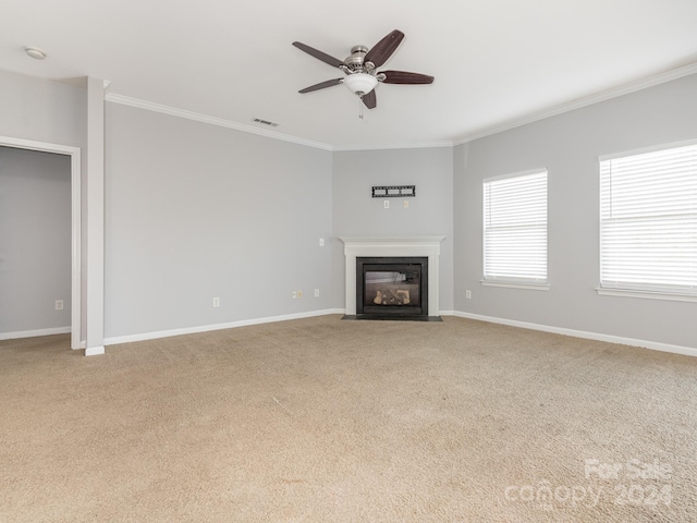 unfurnished living room with ceiling fan, crown molding, and light carpet