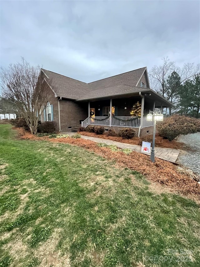 view of front of home featuring covered porch and a front lawn