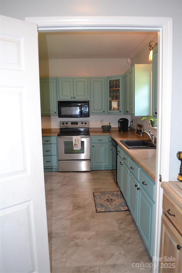 kitchen with decorative light fixtures, sink, and black appliances