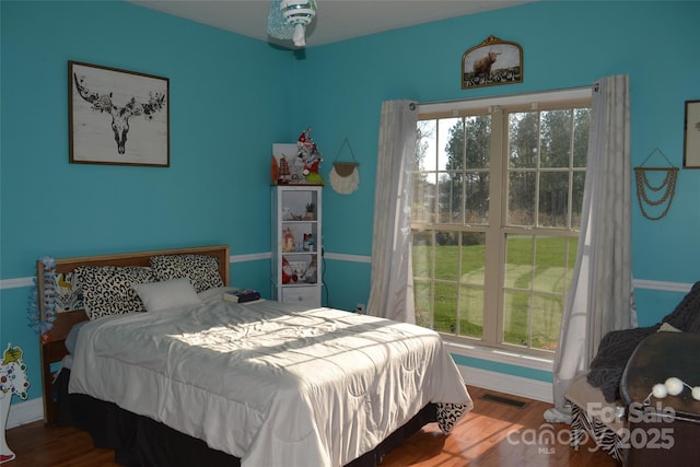 bedroom featuring hardwood / wood-style floors and multiple windows