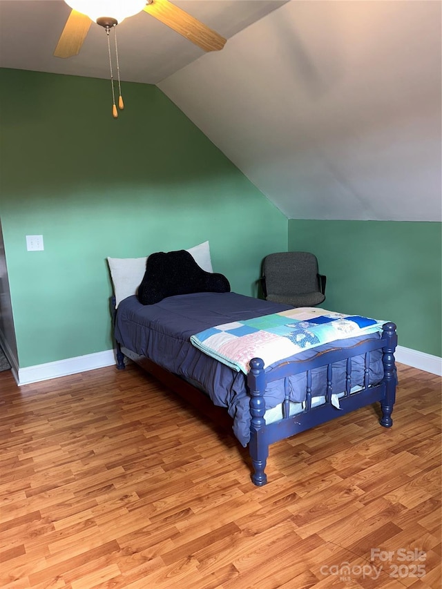 bedroom featuring ceiling fan, light hardwood / wood-style flooring, and lofted ceiling