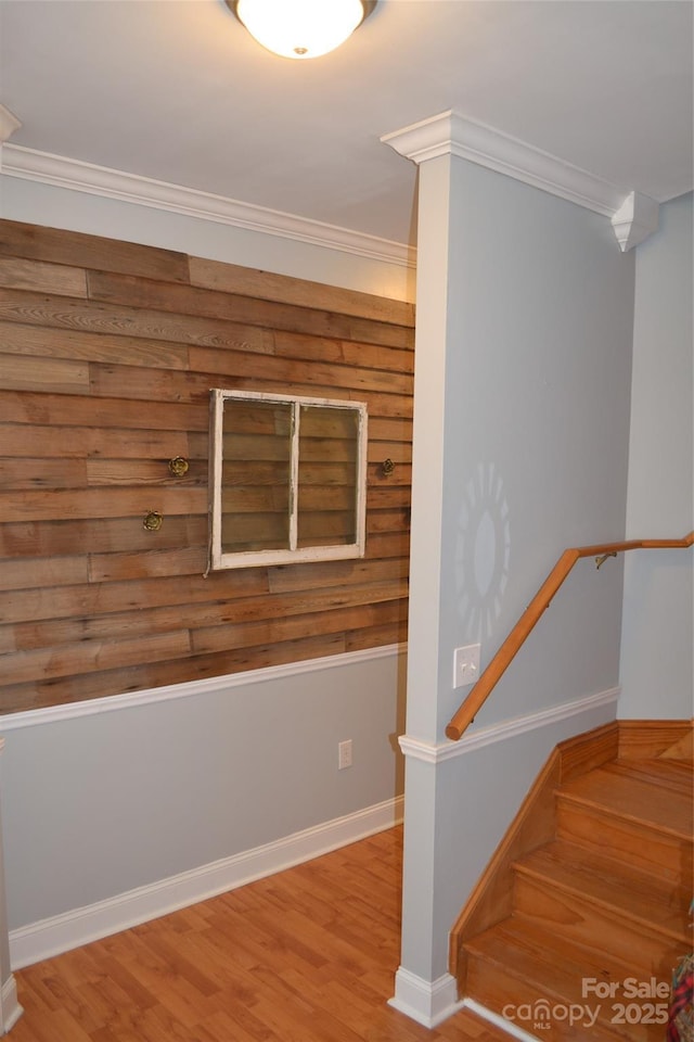 stairway with hardwood / wood-style flooring and ornamental molding