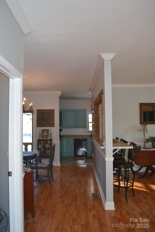 hall featuring an inviting chandelier, ornamental molding, and dark hardwood / wood-style flooring