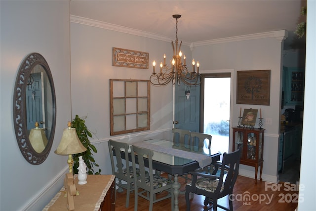 dining area featuring crown molding, dark hardwood / wood-style floors, and an inviting chandelier