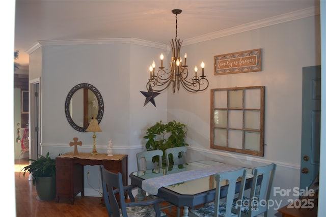 dining area featuring an inviting chandelier, ornamental molding, and hardwood / wood-style floors