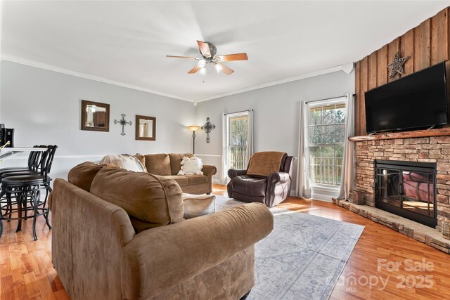 158 White Rd, Wadesboro, NC 28170 - living room with a stone fireplace, crown molding, light wood-type flooring, and a ceiling fan