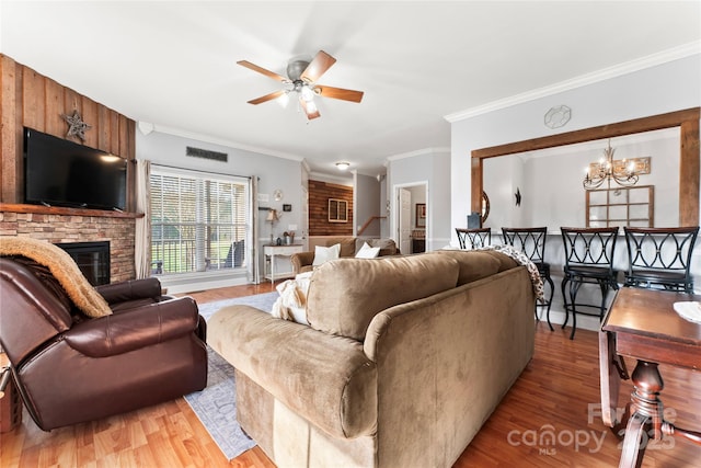 158 White Rd, Wadesboro, NC 28170 - living room featuring light wood finished floors, visible vents, ornamental molding, ceiling fan with notable chandelier, and a fireplace