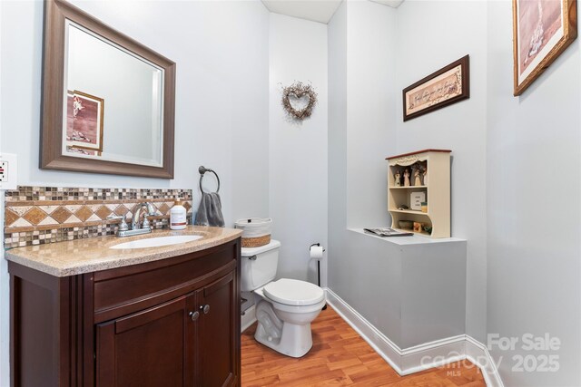 158 White Rd, Wadesboro, NC 28170 - bathroom featuring toilet, wood finished floors, decorative backsplash, baseboards, and vanity