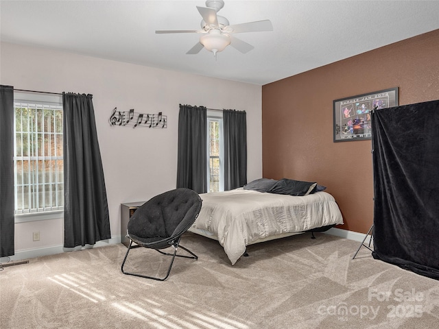 bedroom featuring carpet flooring, multiple windows, visible vents, and baseboards