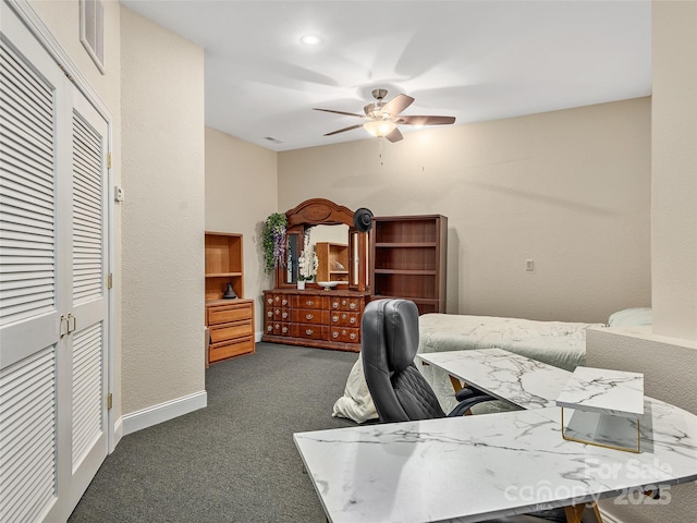 carpeted office with baseboards, visible vents, and ceiling fan