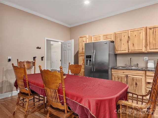 dining room featuring baseboards, wood finished floors, and crown molding