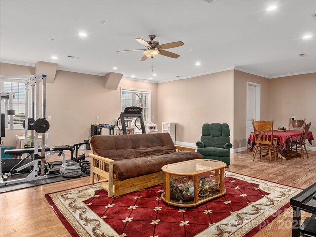 living area featuring recessed lighting, baseboards, wood finished floors, and crown molding