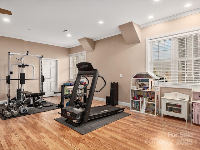 exercise area with visible vents, wood finished floors, recessed lighting, crown molding, and baseboards